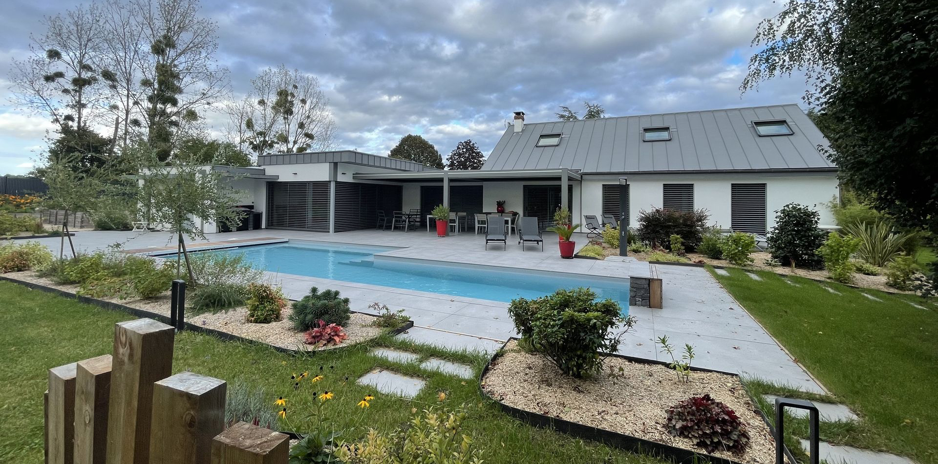Photo de la maison, de la terrasse et la piscine depuis le jardin de la maison Courtasaule